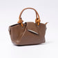 "Avérie Knot Bag Mocha Luxe signature knot handle close-up"
